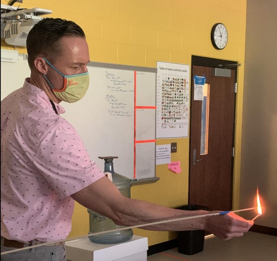 Chemistry teacher Matthew Featherstun lights wooden splint. He is creating a reaction between oxygen and ethanol. 